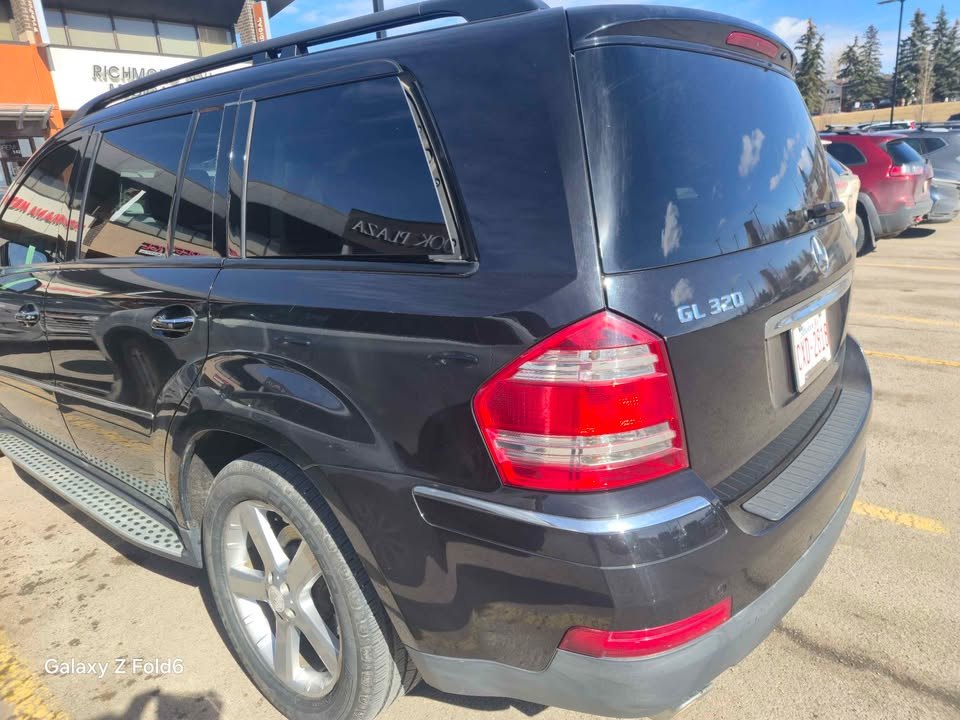 Rear three-quarter view of the black GL 320 BlueTEC with the GL 320 badge on the tailgate