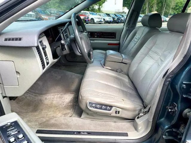 Gray leather front seats and dashboard of the 1994 Cadillac Fleetwood seen through the passenger door
