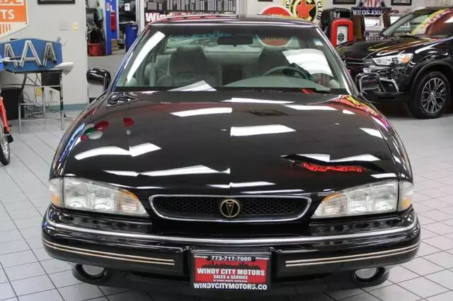 Front view of a black 1994 Pontiac Bonneville SE sedan in a dealer showroom, with a Windy City Motors plate frame