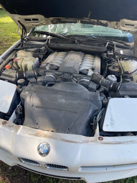 Engine bay of the BMW 850i with the hood open, showing the V12 and its intake plenum