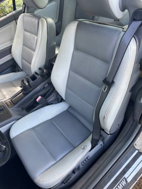 Gray leather front seats of the BMW 850i with their built-in seat belts